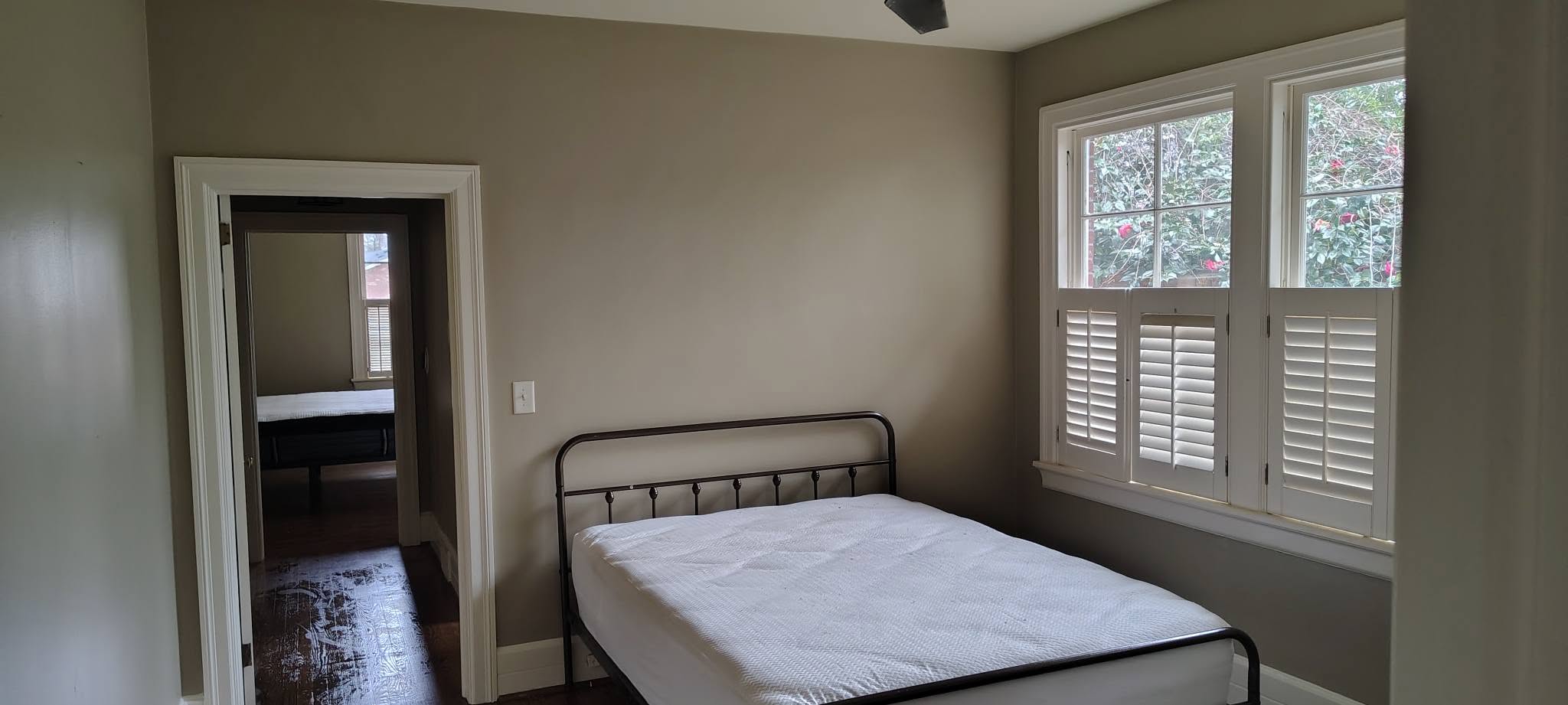 Bedroom with taupe painted walls and plantation shutters