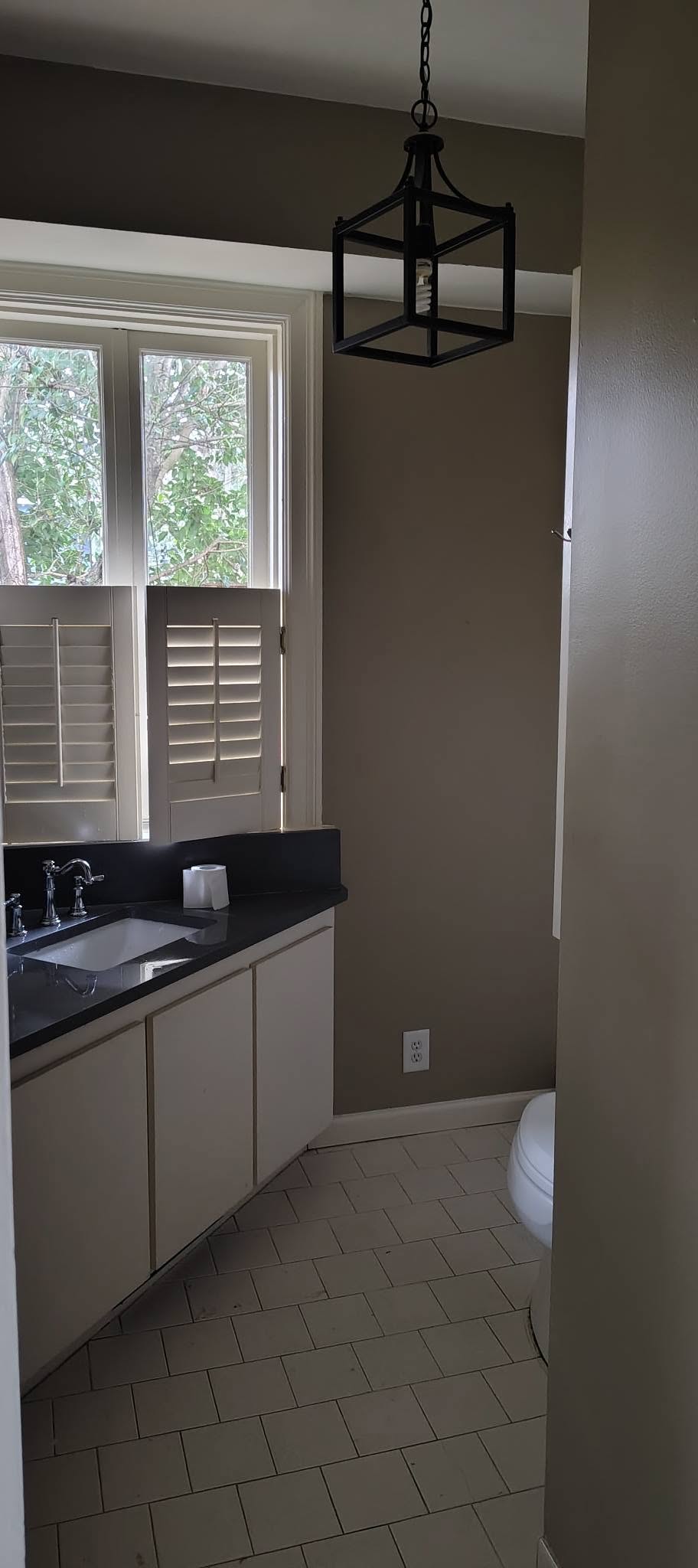 Bathroom with cream vanity and pendant light